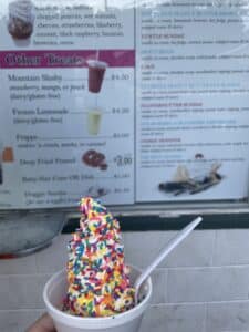 Ice cream in a dish with sprinkles in front of a blurry menu