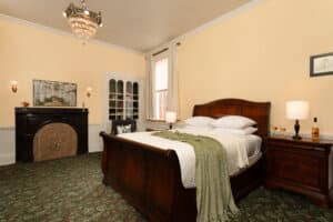 Library Room has a queen antique sleigh bed and an antique fireplace. Bookshelves are built into the wall