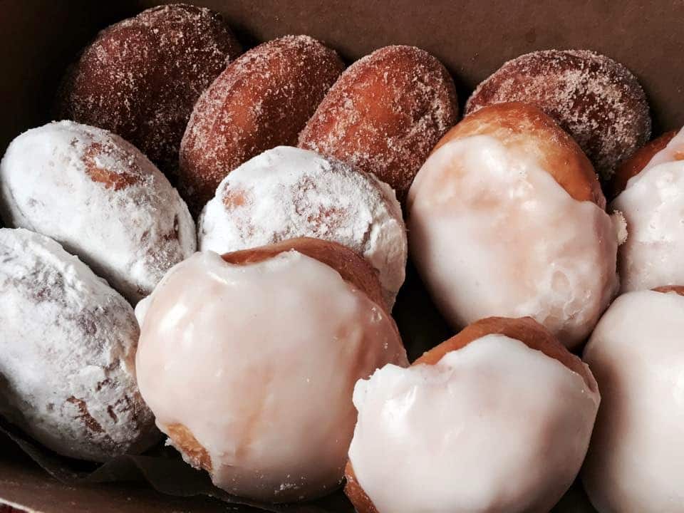 Delicious doughnuts layered. Iced, Powdered sugar, and glazed.