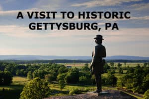 A PHOTO OF THE GENERAL WARREN STATUE ON TOP OF A HILL OVERLOOKING THE GETTYSBURG BATTLEFIELDS.