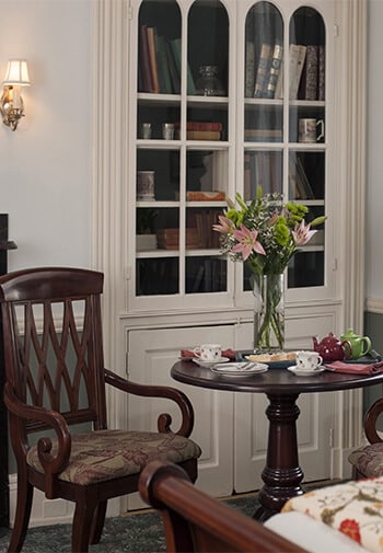 english style chair and table in front of a white bookcase 