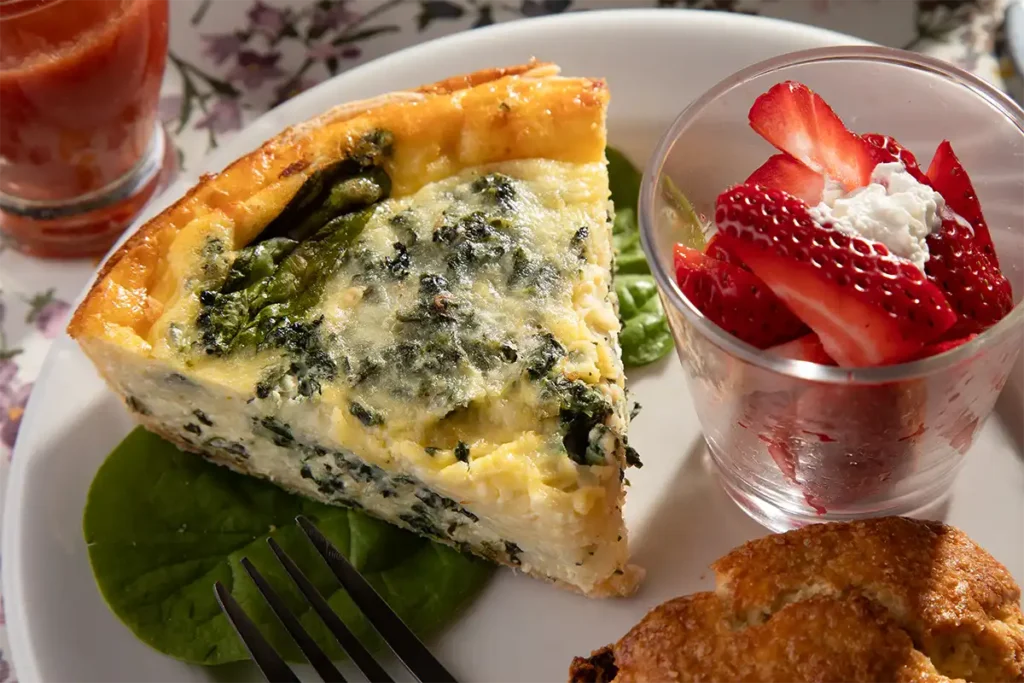 Greek Quiche on a plate with strawberries and a scone